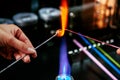 Shaping glass bead in fire, Glass Making Artisan in His Workshop