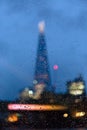 The Shard, blurred thru a window full of rain drops - 87-floor glass skyscraper with a jagged peak, with restaurants, offices,