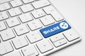 Share blue button with a network icon on a white isolated keyboard. Royalty Free Stock Photo