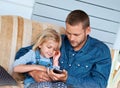 They share a love of music. an adorable little girl sitting on the sofa sharing headphones with her father. Royalty Free Stock Photo