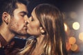 They share a passionate love. Shot of a young couple sharing a romantic kiss together outside at night. Royalty Free Stock Photo
