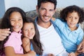 We share the strongest of family bonds. Portrait of a happy single parent family sitting on a sofa and smiling at the Royalty Free Stock Photo