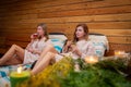 two women are sitting on a bed drinking wine Royalty Free Stock Photo