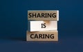 Sharing is caring symbol. Wooden blocks with words `Sharing is caring` on beautiful grey background. Business, sharing is caring