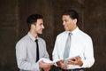 Sharing corporate ideas. Two professional businessmen having a discussion using a digital tablet. Royalty Free Stock Photo