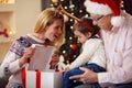 Sharing gift on Christmas- smiling mother giving present to son