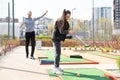 Sharing with golf experience. Cheerful young man teaching his daughter to play mini golf at the day time. Concept of Royalty Free Stock Photo