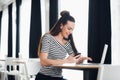 Sharing good business news. Attractive young woman talking on the mobile phone and smiling while sitting at her working Royalty Free Stock Photo