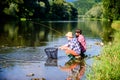 Sharing his secrets. Experienced fisherman show tips to son. Transferring knowledge. Men riverside catching fish Royalty Free Stock Photo