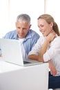 Sharing his technological knowledge. A mature couple looking relaxed as they work on their laptop at home. Royalty Free Stock Photo