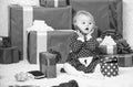 Sharing joy of baby first christmas with family. Little baby girl play near pile of gift boxes. Gifts for child first