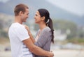 Sharing a loving gaze and a warm embrace. an affectionate young couple at the beach. Royalty Free Stock Photo