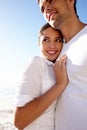 Sharing a loving gaze and a warm embrace. an affectionate young couple at the beach. Royalty Free Stock Photo