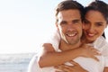 Sharing a loving gaze and a warm embrace. an affectionate young couple at the beach. Royalty Free Stock Photo