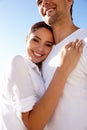 Sharing a loving gaze and a warm embrace. an affectionate young couple at the beach. Royalty Free Stock Photo