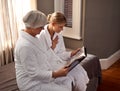 Sharing memories of a happy marriage. Grandmother and granddaughter flipping through a photo album. Royalty Free Stock Photo