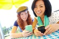 Sharing music via bluetooth. Two teenage girls sitting outside texting on their cellphones. Royalty Free Stock Photo