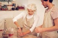 Pleasant aged woman showing how to make pots