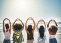 Sharing some beach love. Rearview shot of a group of girlfriends showing heart shapes with their hands.