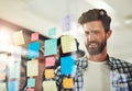 Sharing some new ideas. coworkers using sticky notes on a glass wall during an office meeting. Royalty Free Stock Photo