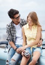 Sharing special moments together. Attractive young couple sitting on the hood of their convertible while out on a Royalty Free Stock Photo