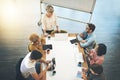 Sharing their thoughts as a team. High angle shot of a businesswoman giving a presentation to her colleagues in an Royalty Free Stock Photo