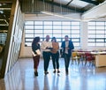 Sharing their thoughts, opinions and ideas. a group of designers having a discussion while walking through a office. Royalty Free Stock Photo