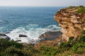 Waterfront lookout on hill with idyllic and amazing seaside landscape of bluff with shrubs, jagged coast with rocks, ocean horizon