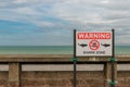 Shark warning information at the beach with a cloudy sky