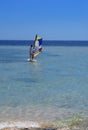 Sharm el-Sheikh, Egypt - March 14, 2018. A girl runs a board with a sail on the mast due to the inclination and turn of the mast.