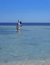 Sharm el-Sheikh, Egypt - March 14, 2018. A girl runs a board with a sail on the mast due to the inclination and turn of the mast.