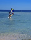 Sharm el-Sheikh, Egypt - March 14, 2018. A girl runs a board with a sail on the mast due to the inclination and turn of the mast.