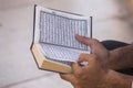 Egyptian man reading the book of Islam, al Quran is a holy book of Islamic religion, Al-Quran in hand - holy book of Muslims.