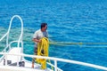 Sharm El Sheikh, Egypt May 08, 2019: Sailor on a pleasure boat holds a yellow rope for mooring a ship Royalty Free Stock Photo