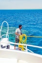 Sharm El Sheikh, Egypt May 08, 2019: Sailor on a pleasure boat holds a yellow rope for mooring a ship Royalty Free Stock Photo