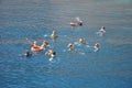 Group of happy people swiming in the open sea, near reef in snorkeling masks. Travel