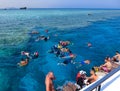 Sharm El Sheikh, Egypt - September 10, 2020: A group of tourists swims in the Red Sea near pleasure boats at Sharm El Sheikh,