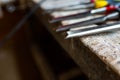 Sharp chisels in row on aged old oak wood workbench