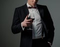 Sharp dressed man wearing jacket with glass of vine