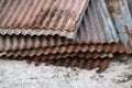 Sharp edges of the rusty metal sheets placed on the floor. Old aged weathered rusty galvanized corrugated iron sheet roof of