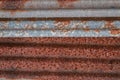 Sharp edges of the rusty metal sheets placed on the floor. Old aged weathered rusty galvanized corrugated iron sheet roof of