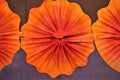 Sharp focus on an orange paper flower in center with two halves on both sides.