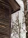 Sharp, frozen icicles hang on the corner of the roof, winter or spring.