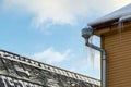 Sharp icicles hanging on the edge of the roof. Melting snow forms icicle Royalty Free Stock Photo