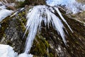 Sharp icicles hanging from a rock formation on a mountain valley in Romania