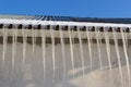 Sharp icicles and melted snow hanging from the eaves of the roof. Beautiful transparent icicles slowly gliding of a roof