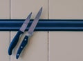 A sharp knife is attached to a magnet attached to the kitchen wall