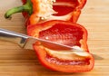 Sharp knife cutting fresh red bell pepper into quarters, closeup Royalty Free Stock Photo