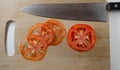 A sharp knife and three very thin slices of a tomato