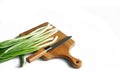 Sharp knife, vintage solid oak wooden cutting board and chopped green onions on a white background. Concept for making a rustic Royalty Free Stock Photo